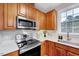 Well-equipped kitchen featuring stainless steel appliances, light countertops, and wood-stained cabinetry at 833 Providence Glen Dr, Chapel Hill, NC 27514