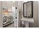 Stylish half bathroom featuring a pedestal sink, decorative mirror, and elegant decor at 938 Haybeck Ln, Apex, NC 27523