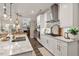 This open kitchen features white cabinets, a granite countertop, and stainless steel appliances at 938 Haybeck Ln, Apex, NC 27523