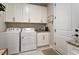 Functional laundry room with white washer and dryer, storage cabinets, and granite countertop at 938 Haybeck Ln, Apex, NC 27523
