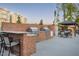 Outdoor kitchen area with stainless steel grills, brick accents, and a covered dining space for entertaining at 938 Haybeck Ln, Apex, NC 27523