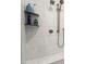 Close up of modern shower with chrome fixtures, built in niche, and white marble-style tile at 938 Haybeck Ln, Apex, NC 27523
