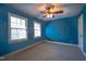 Carpeted bedroom featuring two windows and a ceiling fan at 94 Cedar Hills Cir, Chapel Hill, NC 27514
