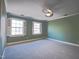 Bedroom with green walls, carpet, ceiling fan, and two windows with shutters at 94 Cedar Hills Cir, Chapel Hill, NC 27514