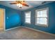 Bright bedroom featuring two windows, blue walls, carpet, and a ceiling fan at 94 Cedar Hills Cir, Chapel Hill, NC 27514