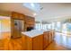 An open kitchen features a brick fireplace, stainless steel refrigerator, and lots of light at 94 Cedar Hills Cir, Chapel Hill, NC 27514