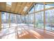 Bright sunroom with wood floors, skylights, ceiling fan, and walls of windows overlooking the wooded yard at 94 Cedar Hills Cir, Chapel Hill, NC 27514