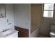 Bathroom featuring a single sink vanity, a shower-tub combo, and a window for natural light at 1005 N Wilson Ave, Dunn, NC 28334
