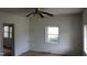 A bedroom with a ceiling fan, windows, and simple interior details at 1005 N Wilson Ave, Dunn, NC 28334