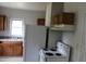 Kitchen with stove, refrigerator, range hood, upper cabinets, and a window allowing natural light at 1005 N Wilson Ave, Dunn, NC 28334