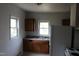 Kitchen area showing a double sink, refrigerator, upper and lower cabinets with natural light from two windows at 1005 N Wilson Ave, Dunn, NC 28334