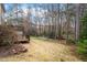 Lush backyard with mature trees, a wooden deck, and well-maintained landscaping at 1021 Whetstone Ct, Raleigh, NC 27615