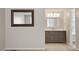 Bathroom vanity featuring grey cabinetry, marble countertop, modern mirror, and lighting at 1021 Whetstone Ct, Raleigh, NC 27615