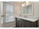 Bathroom vanity with grey cabinetry, marble countertop, modern mirror, and natural lighting at 1021 Whetstone Ct, Raleigh, NC 27615