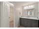 Bathroom vanity with grey cabinetry, marble countertop, modern mirror, and walk-in closet access at 1021 Whetstone Ct, Raleigh, NC 27615