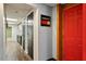 Hallway with a Guinness mirror, red door, and view into another finished room at 1021 Whetstone Ct, Raleigh, NC 27615