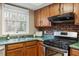 A view of the kitchen with wood cabinets, stainless appliances, and a window view at 1021 Whetstone Ct, Raleigh, NC 27615