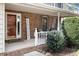 Cozy covered front porch with brick siding, comfortable seating, and a welcoming 'Home Sweet Home' sign at 1021 Whetstone Ct, Raleigh, NC 27615