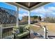 Relaxing back porch with seating overlooking a spacious, tree-lined backyard and blue skies at 1024 Jensen Grove Ct, Fuquay Varina, NC 27526