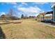 Large, flat backyard with healthy green grass, mature trees, a wooden privacy fence and outdoor living at 1024 Jensen Grove Ct, Fuquay Varina, NC 27526