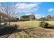 A large flat backyard with healthy grass, trees, a wooden privacy fence and inviting sunshine at 1024 Jensen Grove Ct, Fuquay Varina, NC 27526