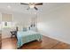 Bright bedroom featuring hardwood floors, neutral walls, patterned blinds, and a cozy bed with blue comforter at 1024 Jensen Grove Ct, Fuquay Varina, NC 27526