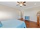 View of bedroom with hardwood floors, ceiling fan, doors leading to other rooms, and a blue accent dresser at 1024 Jensen Grove Ct, Fuquay Varina, NC 27526