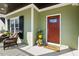 Cozy front porch featuring stylish seating, potted plants, and a welcoming red front door at 1024 Jensen Grove Ct, Fuquay Varina, NC 27526