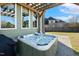 Hot tub under wooden pergola with view of the large home and fenced in backyard for privacy at 1024 Jensen Grove Ct, Fuquay Varina, NC 27526