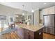 Open concept kitchen features large island with granite counters and stainless steel appliances at 1024 Jensen Grove Ct, Fuquay Varina, NC 27526