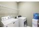 Functional laundry room featuring a washer, dryer, shelving, and a water cooler for added convenience at 1024 Jensen Grove Ct, Fuquay Varina, NC 27526