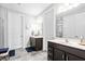 Bright bathroom with double sink vanity, tile floors, and a glass-enclosed shower at 105 Olde Liberty Dr, Youngsville, NC 27596