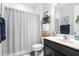 Well-lit bathroom features a shower with a curtain, a vanity with a dark cabinet and decor shelves at 105 Olde Liberty Dr, Youngsville, NC 27596