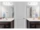 Bright bathroom featuring double vanities, white countertops, and modern lighting fixtures, with a door centered between the two at 105 Olde Liberty Dr, Youngsville, NC 27596