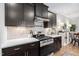 Modern kitchen features dark cabinetry, stainless steel appliances, white countertops, and herringbone backsplash for a stylish design at 105 Olde Liberty Dr, Youngsville, NC 27596