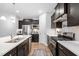 Contemporary kitchen featuring dark cabinets, stainless steel appliances, a large island, and hardwood flooring for a seamless look at 105 Olde Liberty Dr, Youngsville, NC 27596