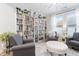 Bright living room featuring a bookcase, comfortable seating, and a stylish ottoman at 105 Olde Liberty Dr, Youngsville, NC 27596