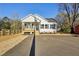 Inviting single-story home with a classic design, wooden porch, and a neatly paved driveway at 109 Faucette Ave, Burlington, NC 27215