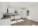 Contemporary kitchen featuring stainless steel appliances, granite countertops, and minimalist white cabinets at 109 Faucette Ave, Burlington, NC 27215