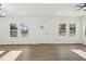 Spacious room featuring light wood floors, abundant natural light from large windows, and a ceiling fan at 109 Faucette Ave, Burlington, NC 27215