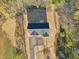 Aerial view of a house with black roof, long driveway, and surrounded by straw-covered lawn at 111 Faucette Ave, Burlington, NC 27215