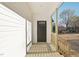 Covered front porch with wood flooring, railings, and a dark-stained front door at 111 Faucette Ave, Burlington, NC 27215