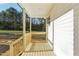 Spacious covered porch with wood flooring, railings, and views of the front yard at 111 Faucette Ave, Burlington, NC 27215