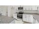 Close-up of kitchen with stainless steel oven, granite counters and bright, white cabinetry at 111 Faucette Ave, Burlington, NC 27215