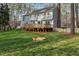 Large backyard with mature trees, lawn, deck, and sandbox, perfect for outdoor activities at 1113 Harvest Mill Ct, Raleigh, NC 27610