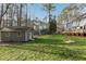 Spacious backyard featuring a storage shed, mature trees, green grass, and a sandbox for outdoor fun at 1113 Harvest Mill Ct, Raleigh, NC 27610