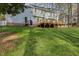 Large backyard with mature trees, a wooden deck, and well-kept lawn offers privacy at 1113 Harvest Mill Ct, Raleigh, NC 27610