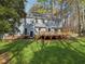 Spacious backyard featuring a large wooden deck, mature trees, and lush green lawn at 1113 Harvest Mill Ct, Raleigh, NC 27610