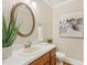 Bathroom features a vanity with a white sink, white countertop, and a round mirror at 1113 Harvest Mill Ct, Raleigh, NC 27610