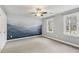 Bright bedroom with a mountain mural, neutral walls, carpet flooring, a ceiling fan, and a window at 1113 Harvest Mill Ct, Raleigh, NC 27610